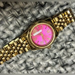 Women’s Michael Kors Pink face watch. It is slim and petite but fits most wrists